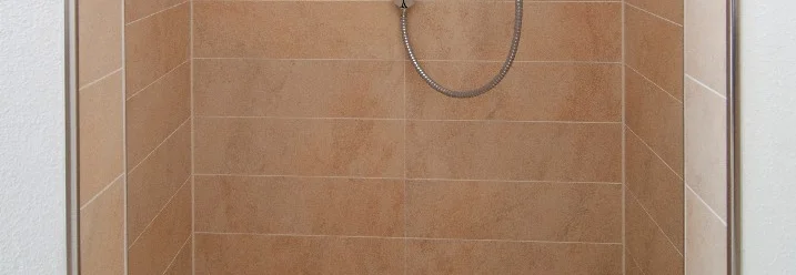 Ebenerdige Dusche mit beigefarbenen Fliesen